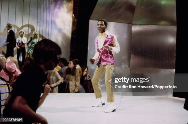 Jamaican singer Desmond Dekker performs on the set of a pop music television show in London circa 1970.