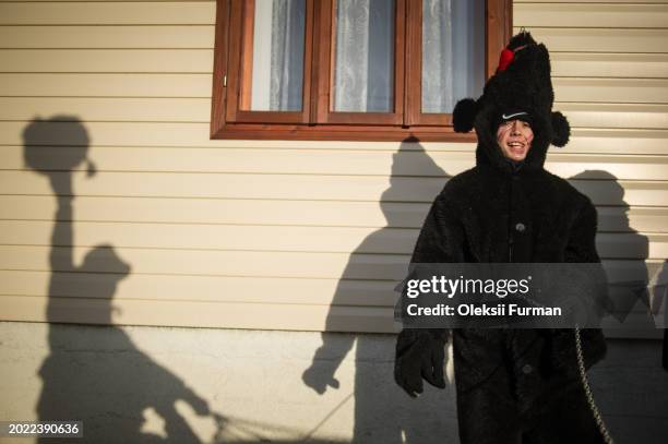 Boy in a Malanka costume sings by one of the houses during the Malanka holiday celebration on January 14, 2014 in Krasnoilsk, Chernivtsi region,...