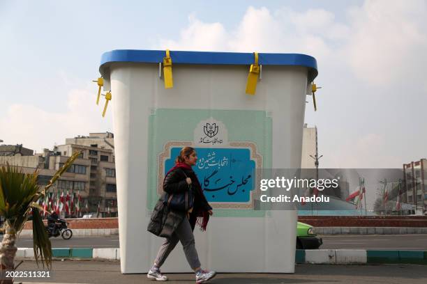 Woman walks past the installation of ballot boxes on the streets of the capital Tehran, Iran during the first day of election campaign to draw...