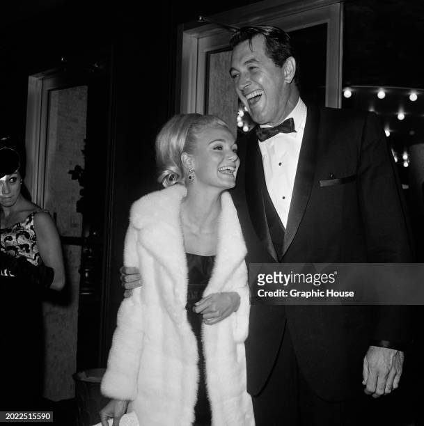 American actress Yvette Mimieux, wearing a white fur coat, and American actor Rock Hudson, who wears a tuxedo and bow tie, attend the 'Mr Wonderful'...