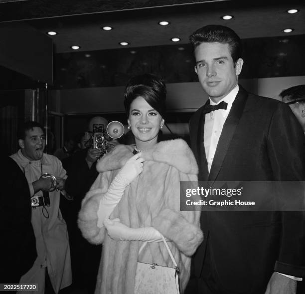 American actress Natalie Wood, wearing a fur coat and white evening gloves, and Warren Beatty, who wears a tuxedo and bow tie, attend the Beverly...