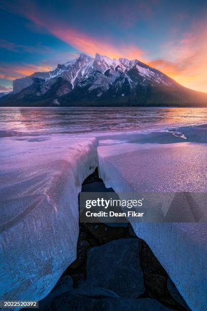 ice cracks in lake minnewanka - rocky mountains sunrise stock pictures, royalty-free photos & images