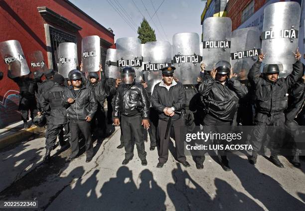 Policemen avoid photographers to take pictures in San Salvador Atenco, Mexico, 04 May 2006, while the authorities try to reestablish the order in the...