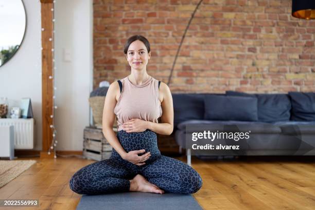 pregnant woman doing yoga prenatal exercise at home - lotus position stock pictures, royalty-free photos & images