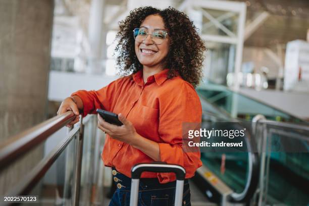 portrait of a woman at the airport looking at camera - business traveller stock pictures, royalty-free photos & images