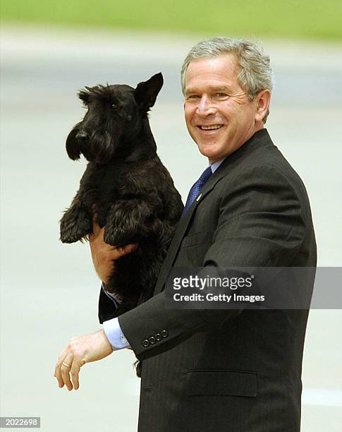 President George W. Bush walks to Marine One while holding his dog Barney May 22, 2003 in Waco, Texas. The president was enroute to his Crawford...