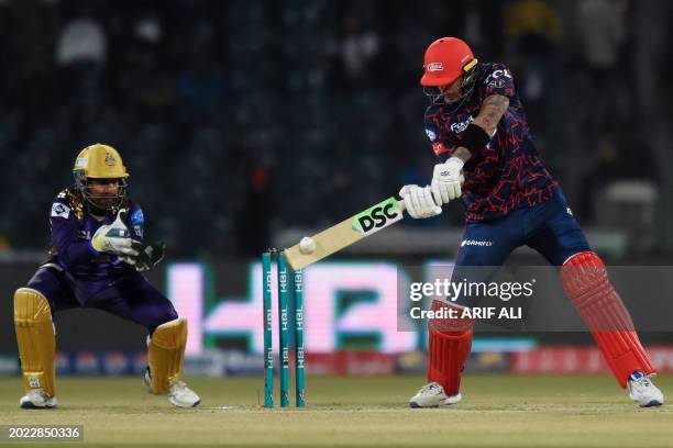 Islamabad United's Alex Hales plays a shot as Quetta Gladiators' wicketkeeper Sarfaraz Ahmed watches during the Pakistan Super League Twenty20...