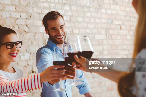 friends toasting with red wine - modern living bricks stock pictures, royalty-free photos & images