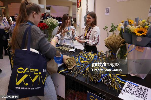 Two Ukrainian women who have opened their own flower shop in Berlin sell flowers and other items tied with ribbons in the blue and yellow of the...