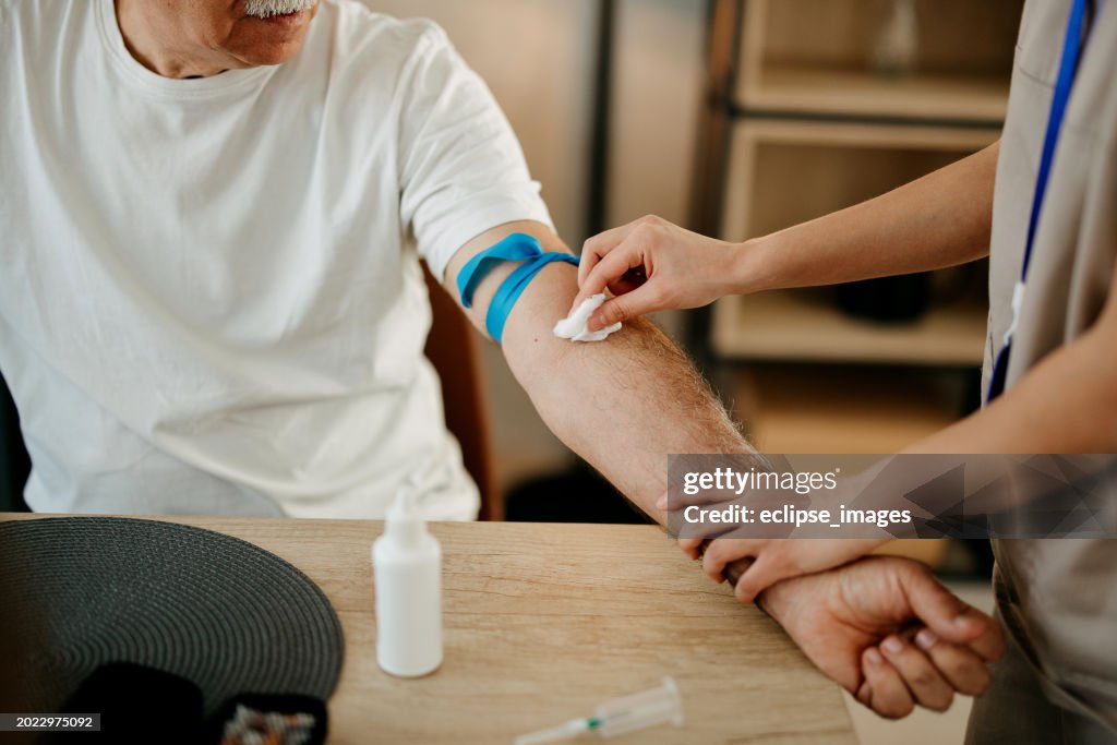 Enfermeira está tirando sangue de paciente