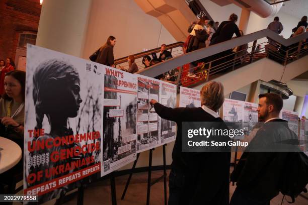 Visitors look at an exhibition relating to a possible repeat of genocide in Ukraine at Cafe Kyiv, a one-day event bringing together panel discussions...