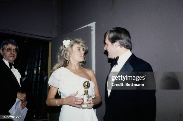 Dyan Cannon, with British actor Anthony Hopkins, after being named best supporting actress for her performance in 'Heaven Can Wait' at the 36th...