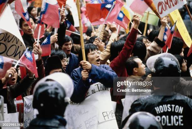 Pro-Taiwan protesters holding placards and Taiwanese flags gather outside the Sheraton Hotel to demonstrate against Chinese Vice Premier Deng...