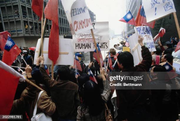 Pro-Taiwan protesters holding placards and flags gather outside the Sheraton Hotel to demonstrate against Chinese Vice Premier Deng Xiaoping's visit...