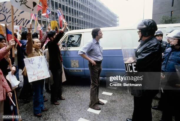 Pro-Taiwan protesters face riot police outside the Sheraton Hotel where they are demonstrating against Chinese Vice Premier Deng Xiaoping's visit to...