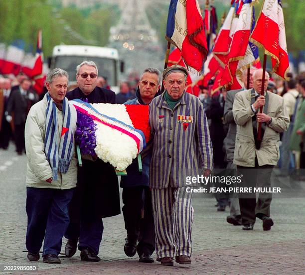 Des anciens déportés portent une gerbe de fleurs, le 28 avril 2001 sur l'avenue des Champs Elysées à Paris, avant la cérémonie de ravivage de la...