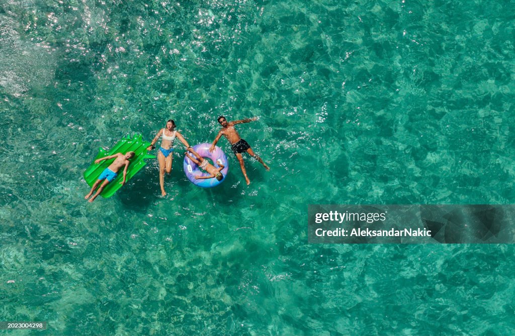 Happy family relaxing on the inflatable swim rings