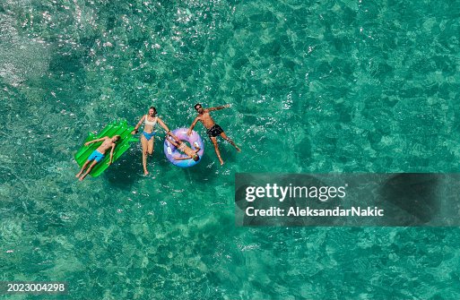 Happy family relaxing on the inflatable swim rings Happy family relaxing on the inflatable swim rings