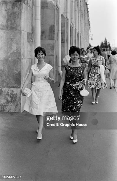 Egyptian actress Faten Hamama and Egyptian actress Amal Farid, with Egyptian actress Sanaa Gamil walking behind , all dressed in sleeveless dresses,...