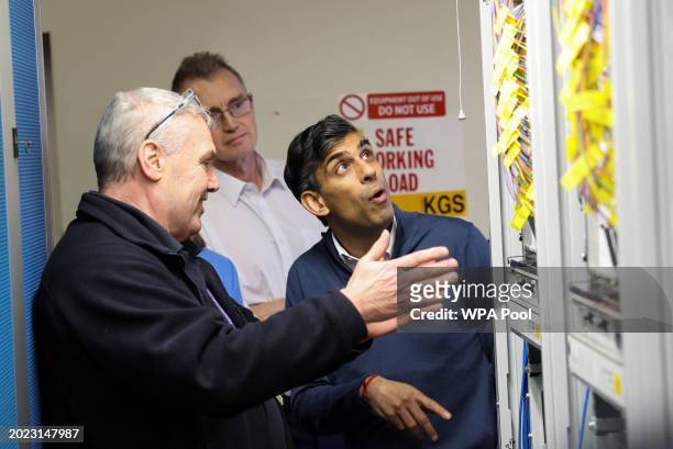 British Prime Minister Rishi Sunak looks at fibre optic cables, during a visit to an Openreach exchange on February 22, 2024 in Anglesey, Wales.