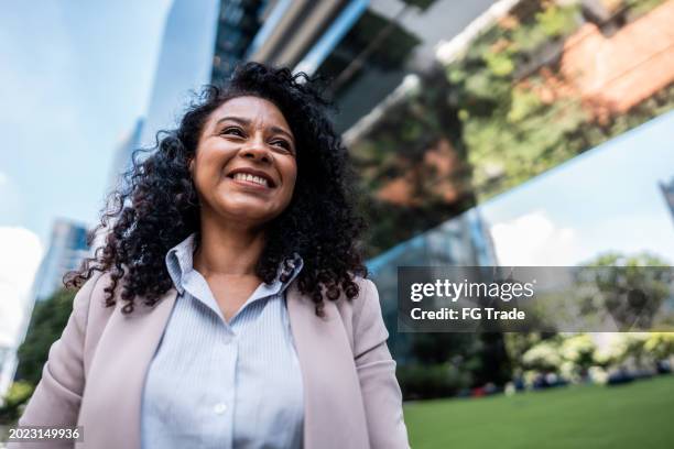 mature businesswoman looking away contemplating outdoors - girl power stock pictures, royalty-free photos & images