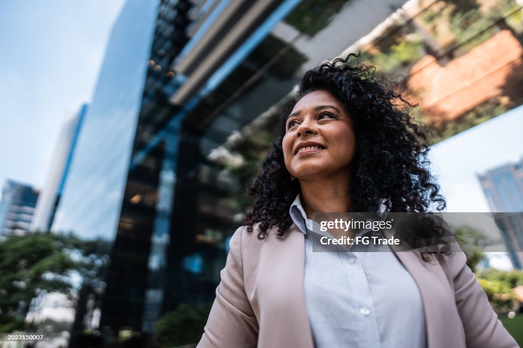 Empresária madura olhando para o lado contemplando ao ar livre