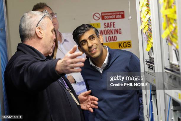 Britain's Prime Minister Rishi Sunak looks at fibre optic cables, during a visit to an Openreach exchange in Anglesey, Wales, on February 22, 2024.