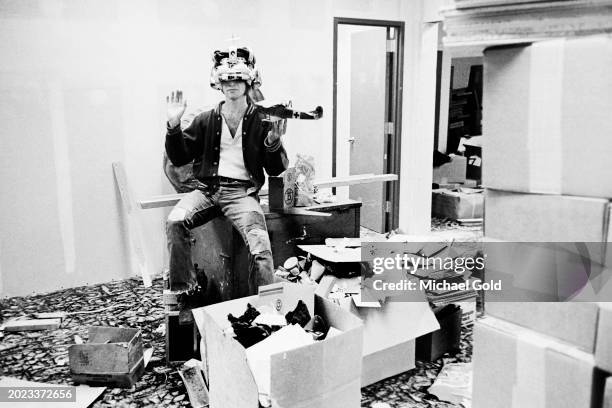 Doug Kenney, National Lampoon magazine founder, with a crown on his head and a model plane in his hand in National Lampoon headquarters, New York...
