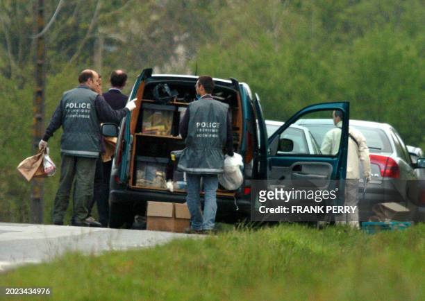 Des policiers discutent après avoir relevé des indices dans un bosquet proche du centre commercial d'Atlantis, le 11 Avril 2007 près de Nantes, dans...