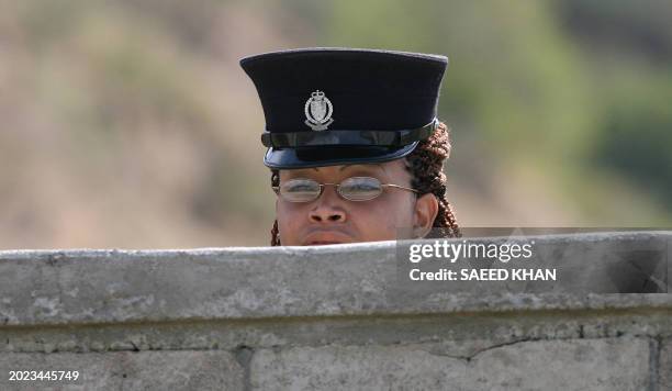 An unidentified security officer watches South African cricketer team training session behind the wall of the Conaree ground on the Caribbean island...