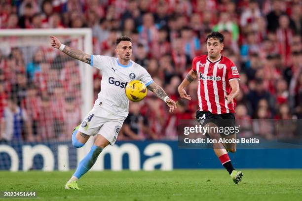 Aleix Garcia of Girona FC competes for the ball with Benat Prados of Athletic Club during the LaLiga EA Sports match between Athletic Club and Girona...