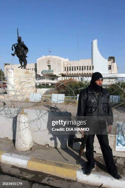 An Iraqi policeman stands guard in front of the municipality building in ousted dictator Saddam Hussein's hometown of Tikrit, 29 December 2006. Iraq...