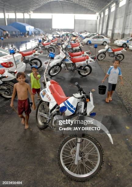 Group of street urchins walk unchallenged into a leaking warehouse in Cebu City, where limousines and police cars to be used during the Association...