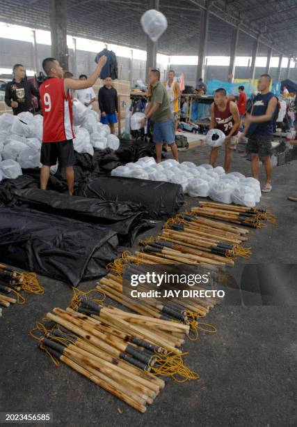 Off-duty anti-riot police assemble their truncheons, shields and helmets 08 January 2007 inside a leaking warehouse in Cebu City, near the site of...