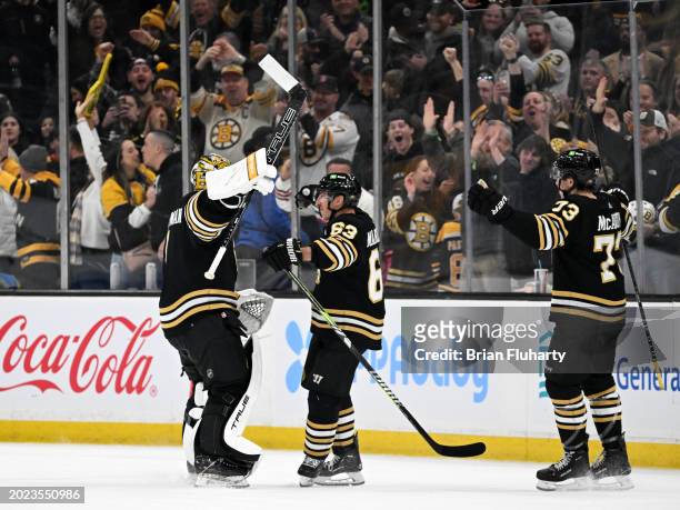 Jeremy Swayman of the Boston Bruins celebrates with Brad Marchand and Charlie McAvoy after a shootout against the Dallas Stars at the TD Garden on...