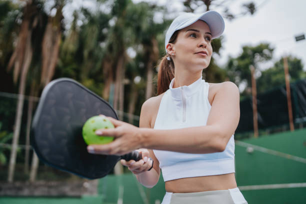 woman serving pickleball game - pickleball stock pictures, royalty-free photos & images
