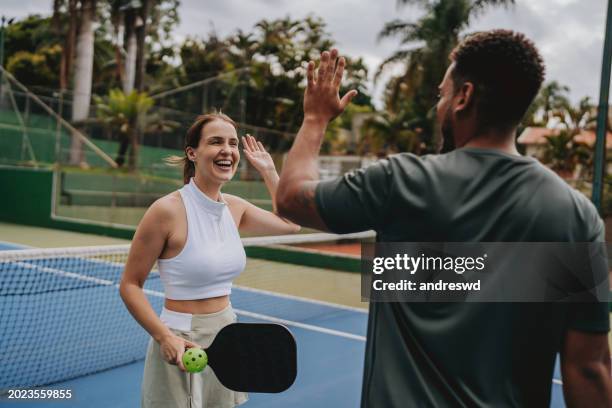 couple playing pickleball celebrate point - paddle ball stock pictures, royalty-free photos & images