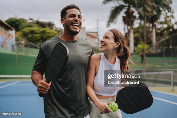 couple playing pickleball celebrate point - tennistrainer stock-fotos und bilder