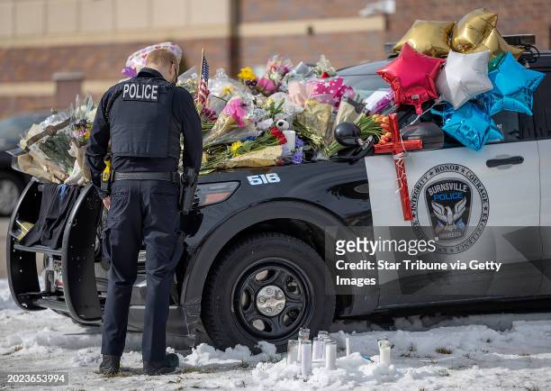 Members of the Eden Prairie Police Department pay their respect on three memorials in front of the Burnsville Police Department in Burnsville, Minn.,...