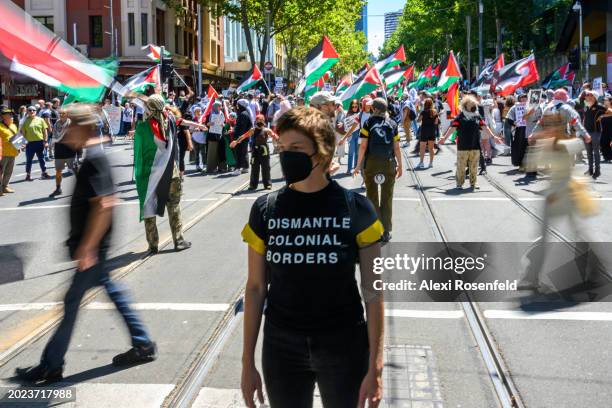 Protestor wearing a dismantle colonial borders t-shirt stands watch during the Save Rafah Now and Free Julian Assange Rally outside the Victoria...
