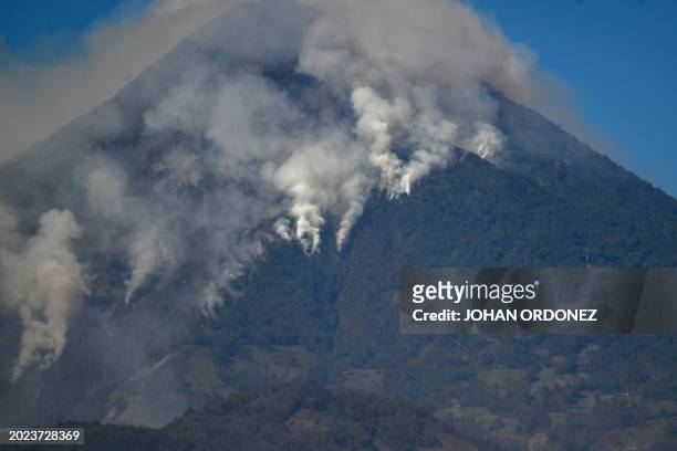 Smoke billows from wildfires on the slopes of the Agua Volcano, as seen from Villa Nueva, Guatemala, on February 22, 2024. A voracious forest fire is...
