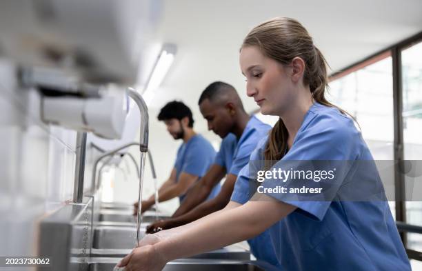 team of doctors washing their hands at the hospital - washing hands stock pictures, royalty-free photos & images
