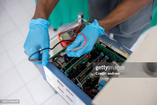 close-up on an electrician fixing medical equipment - medische apparatuur stockfoto's en -beelden