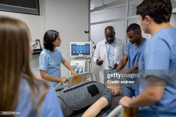 doctor teaching his medical students how to intubate using a dummy - mannequin stock pictures, royalty-free photos & images