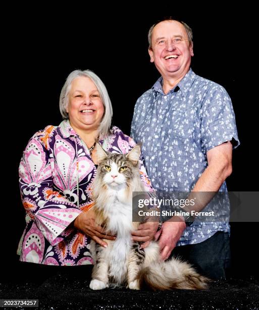 Brian, a silver tabby Maine Coon cat poses with his owners during the GCCF Coventry and Leicester cat show at Stoneleigh Park on February 17, 2024 in...