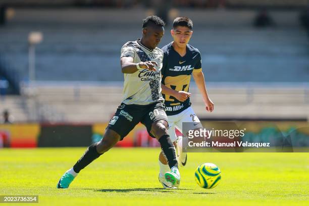 Kevin Velasco of Puebla battles for the ball against Piero Quispe of Pumas during the 6th round match between Pumas UNAM and Puebla as part of the...