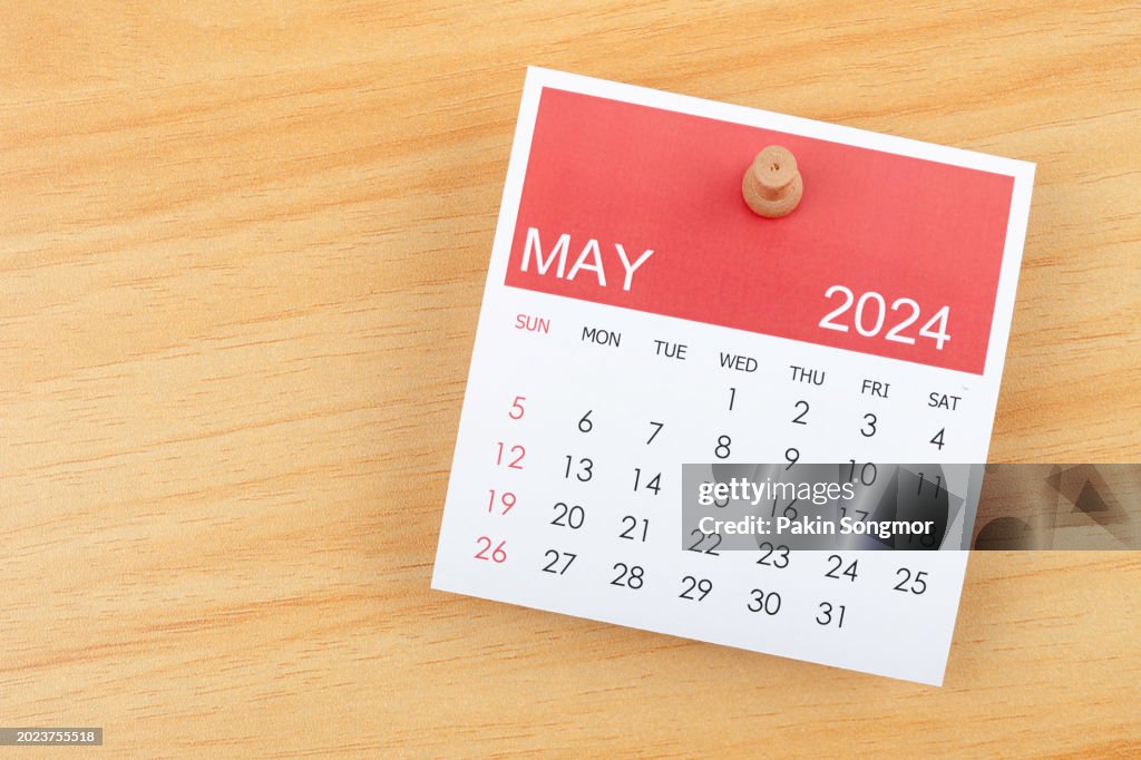 Desk Calendar 2024: May calendar is used to plan daily work and life with a push pin on wooden background.