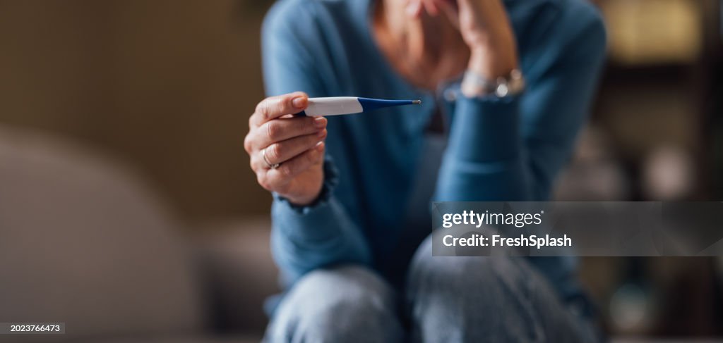 Donna che si sente ansiosa mentre guarda un test di gravidanza negativo