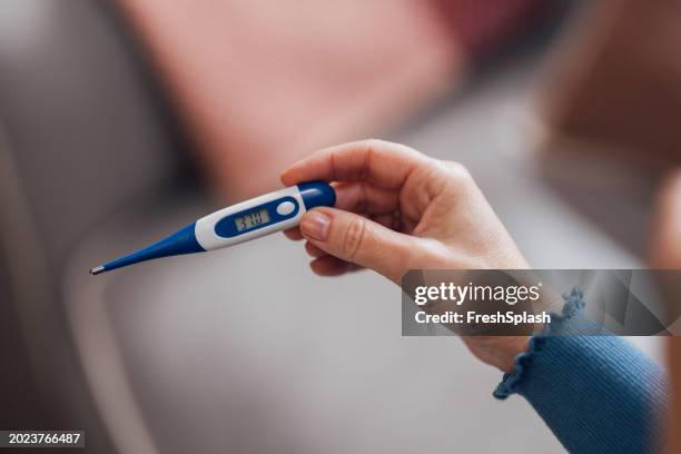 gros plan d’un thermomètre numérique tenant une main affichant une forte fièvre - thermomètre à affichage digital photos et images de collection