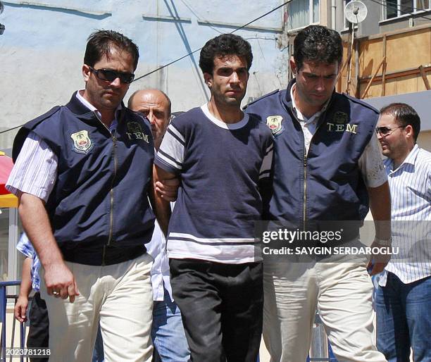 Turkish officers escort one of the suspects of an attack on US consulate to State Security Court in downtown Istanbul on July 13, 2008. Three Turkish...